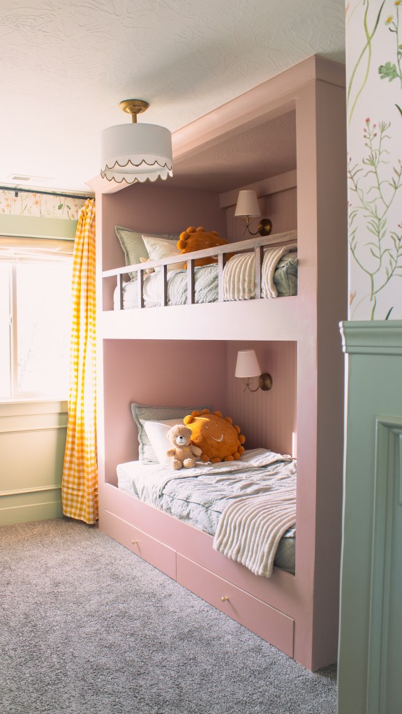 Handmade bunk beds with safety rails and cozy bedding in a floral kids room design