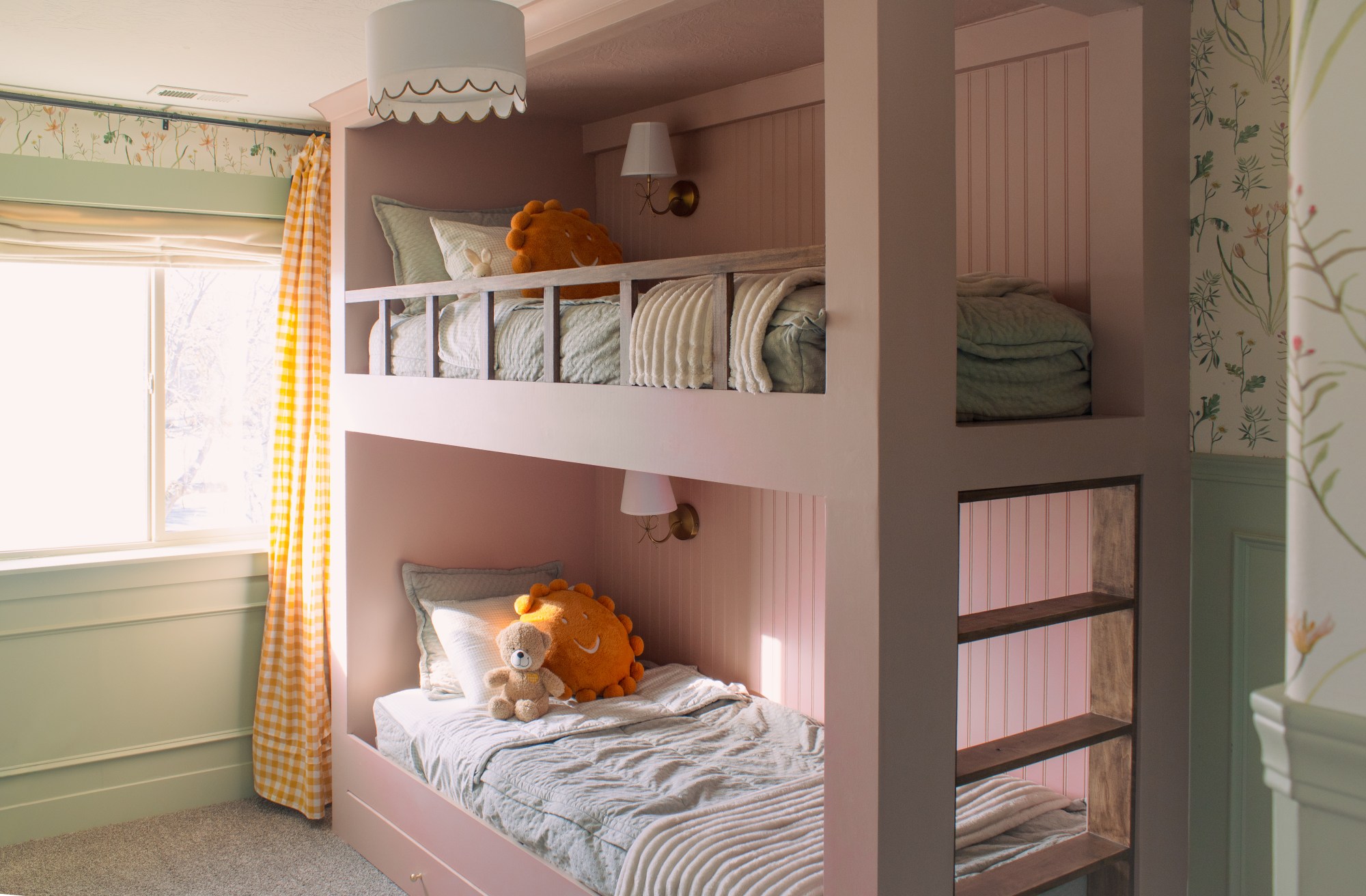 Custom build-in pink bunk beds for a girls bedroom featuring wooden accents, beadboard, ad wallpaper